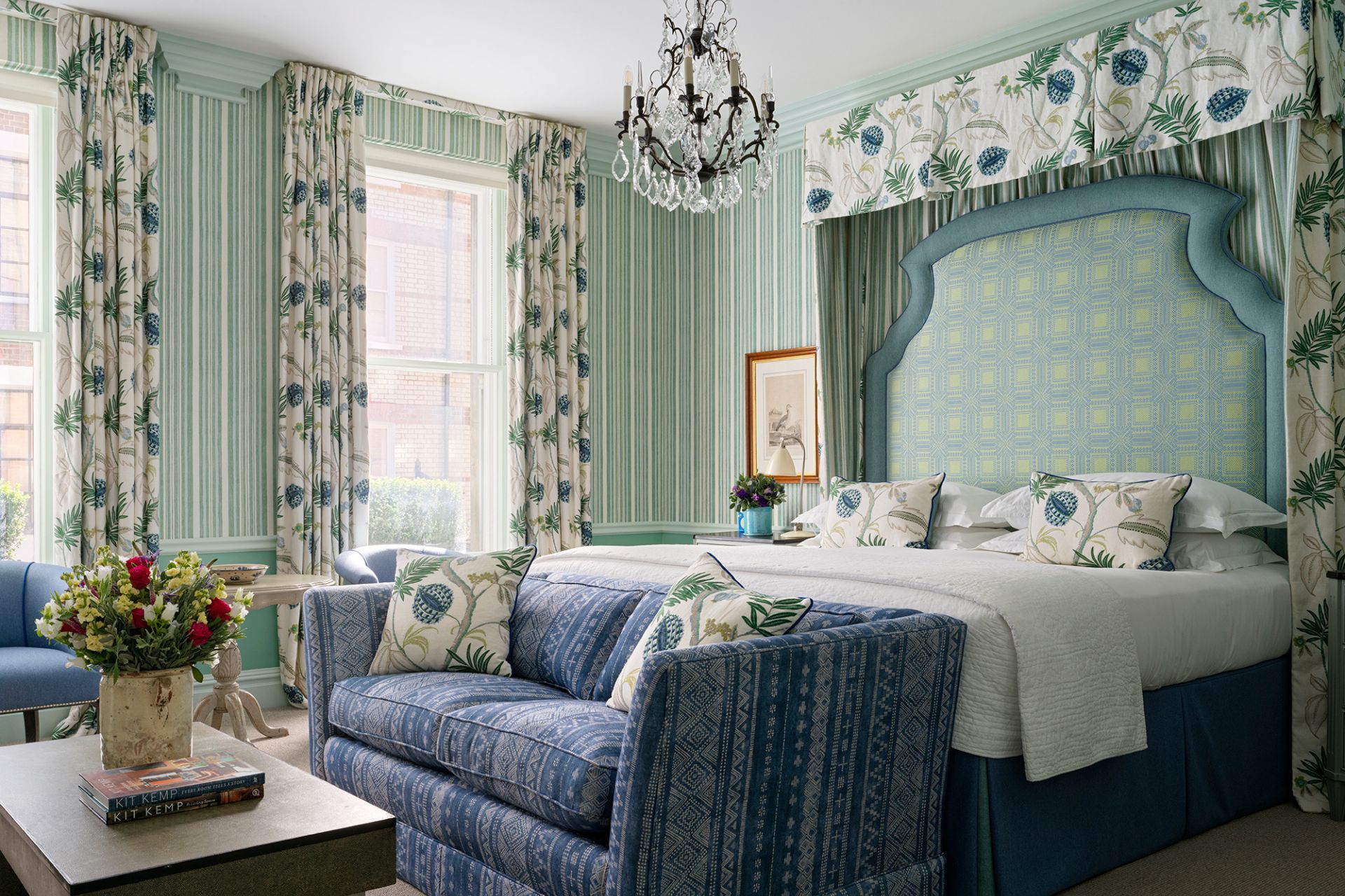 Kit Kemp-designed hotel bedroom featuring duck egg blue walls and a matching headboard alongside powder blue seats.