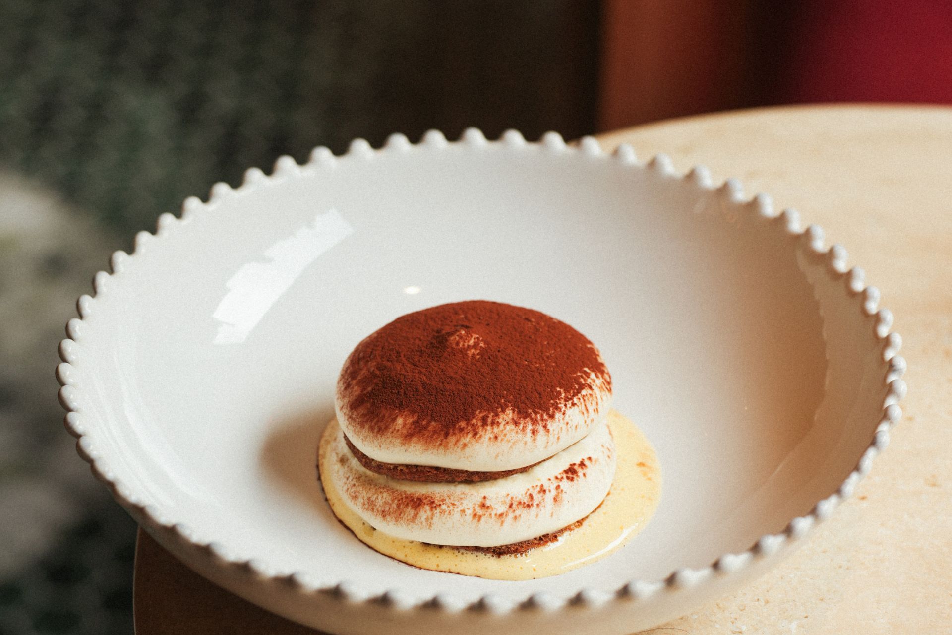 Tiramisu served on a scallop-edged plate.