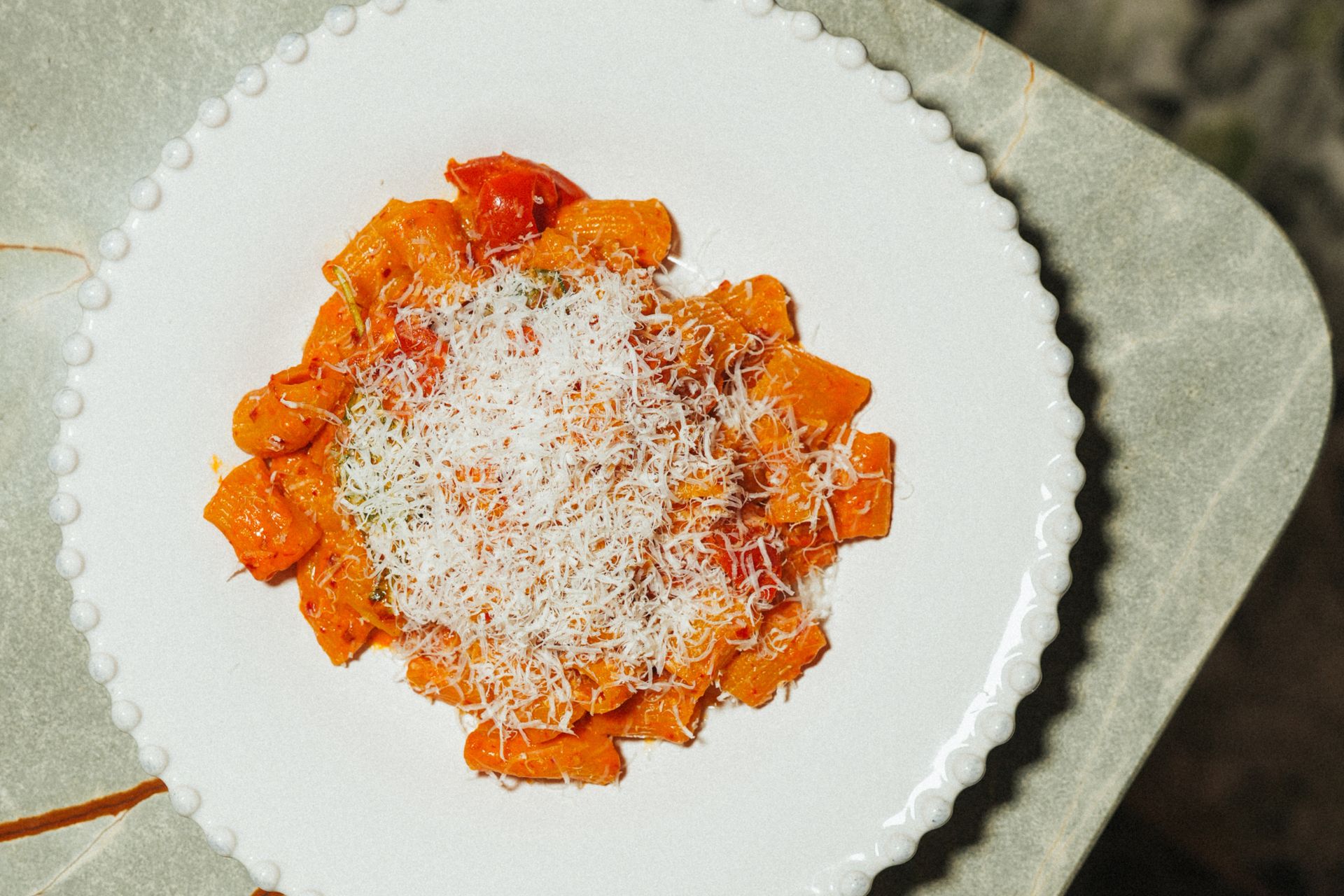 Aerial view of tomato pasta topped with parmesan.