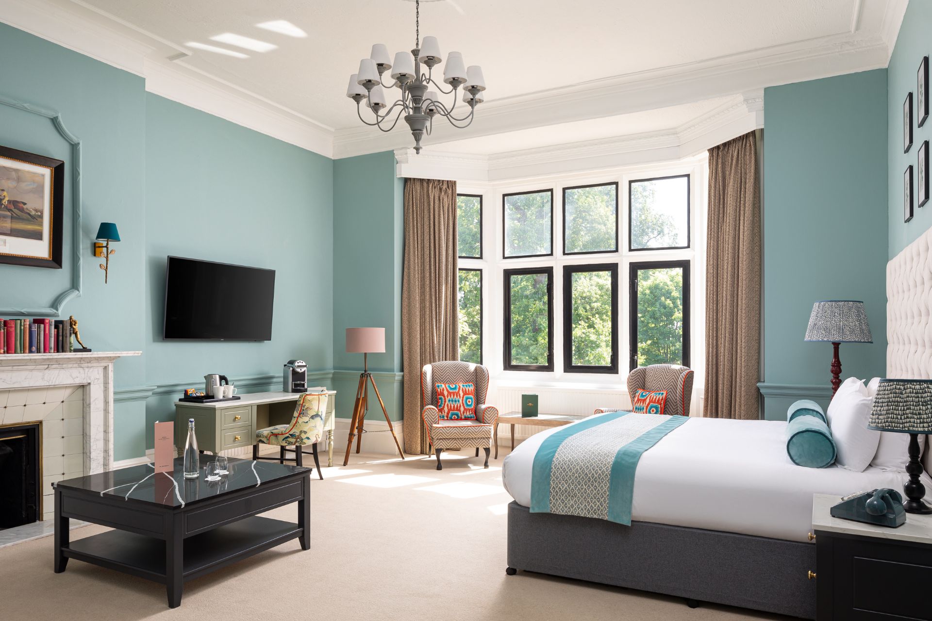 Hotel bedroom with duck egg blue walls, white bed linens and floor-to-ceiling windows.