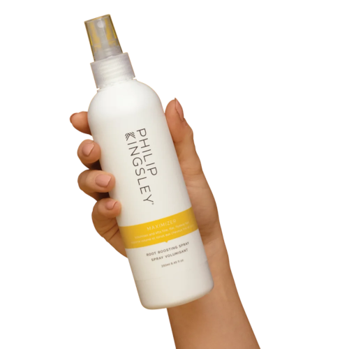 Hand holding white spray bottle