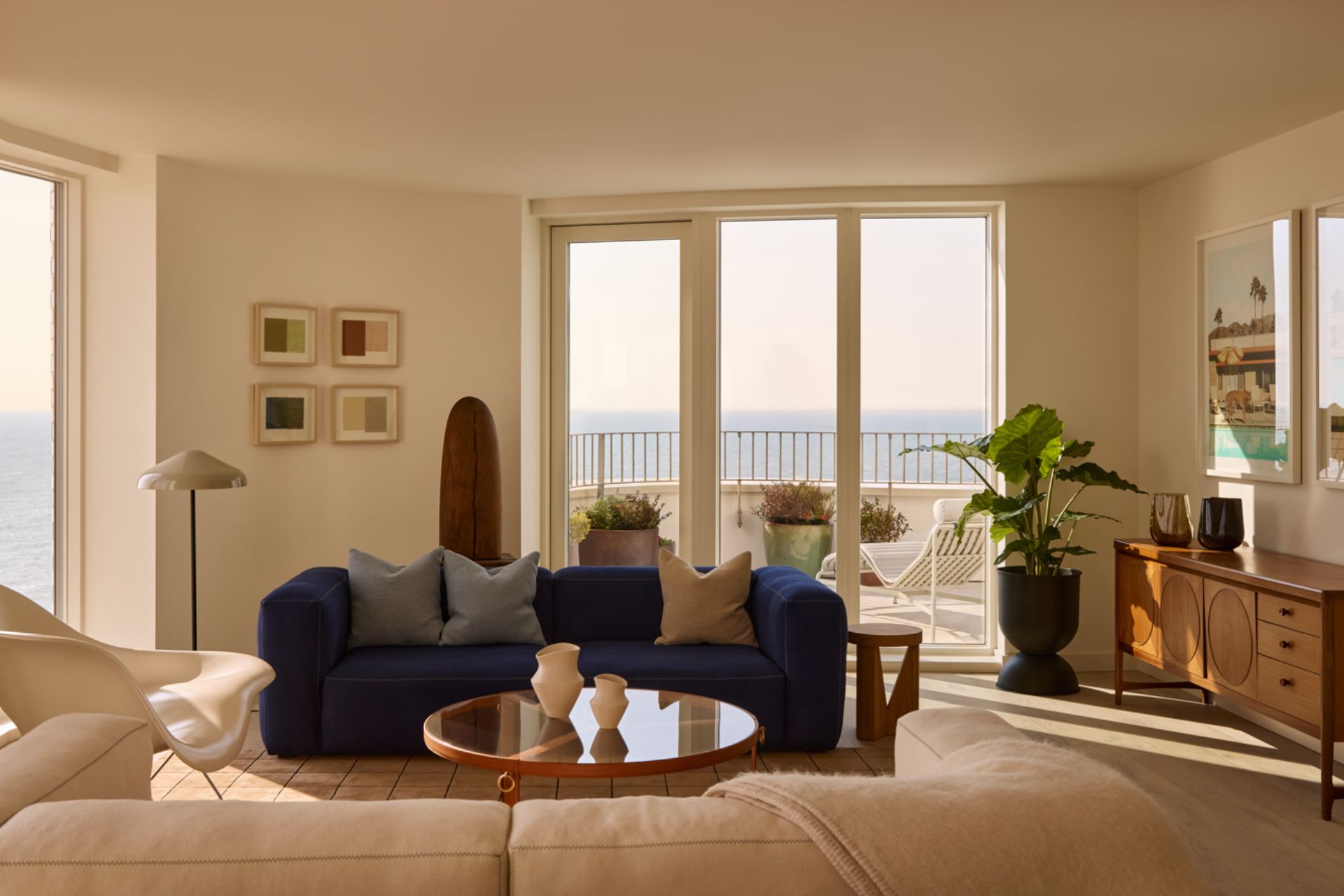 Sea view living room with navy blue velvet sofa and cream sofa