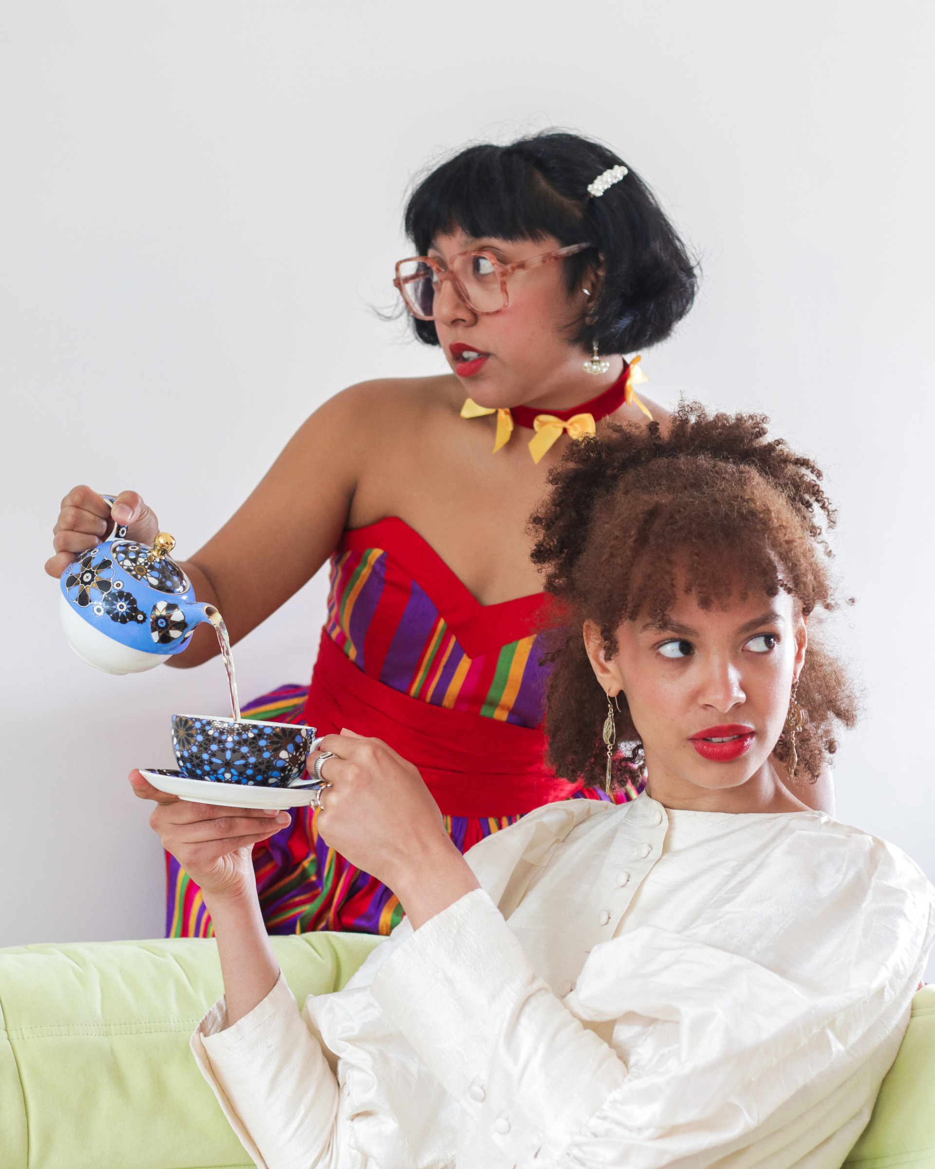 Izzy Manual and Rosie Okotcha with cup and tea pot