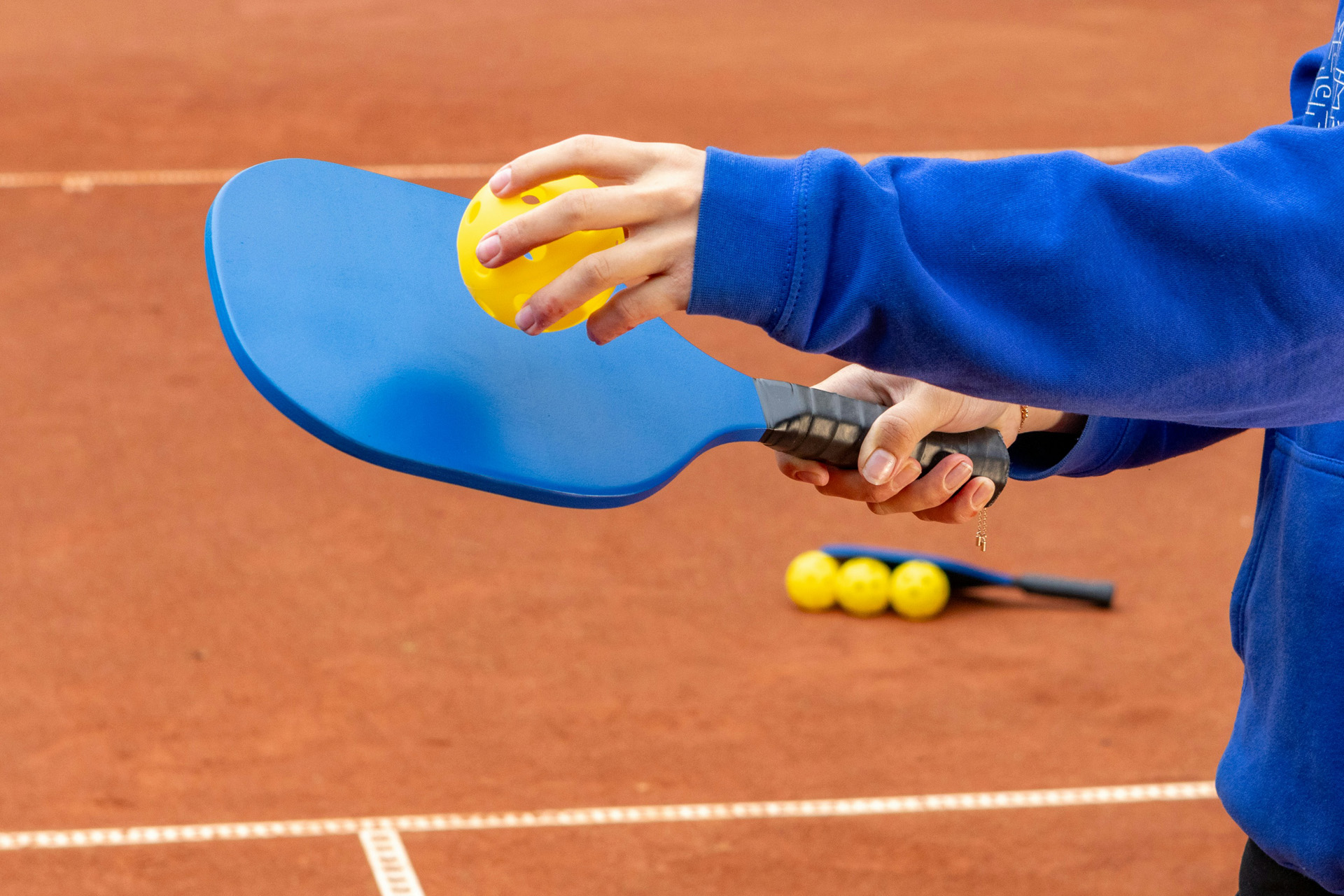 Holding a Pickleball ball to a racket
