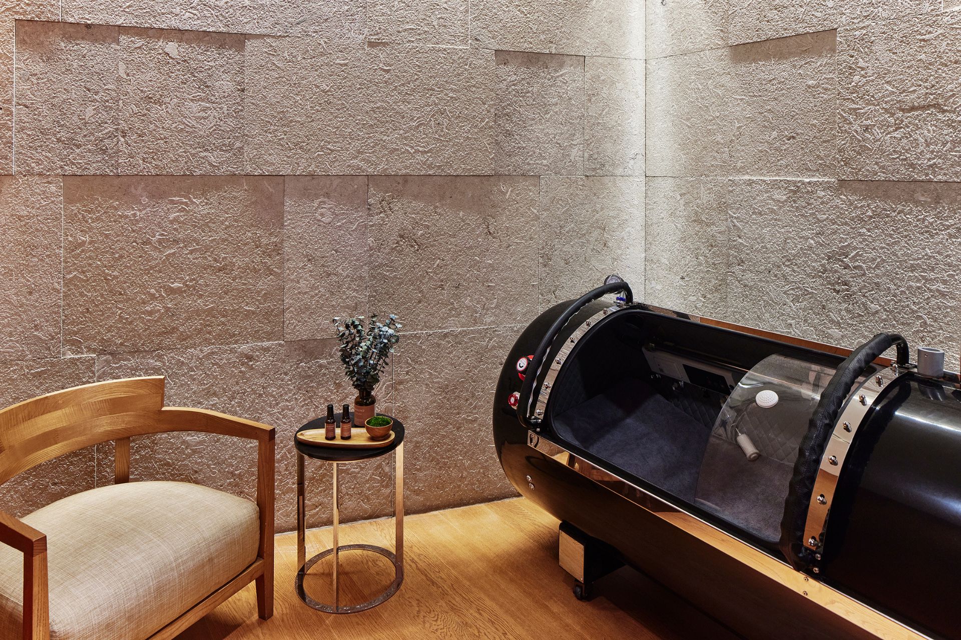 Hyperbaric oxygen chamber with an armchair beside it