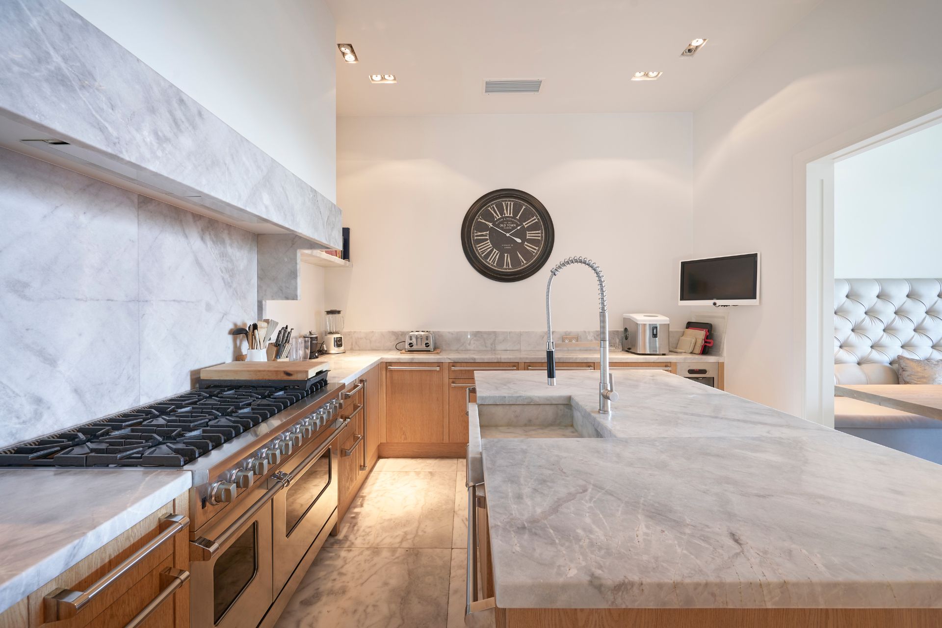 Kitchen with marble worktops and wooden cabinets