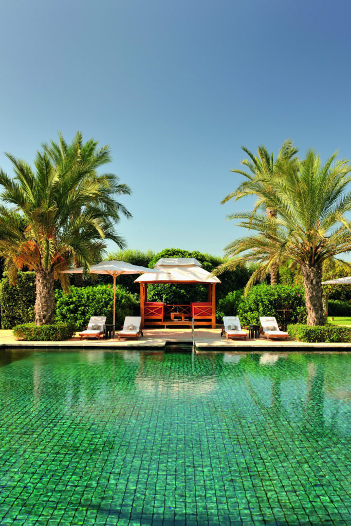 A pool with palm trees at Finca Cortesin