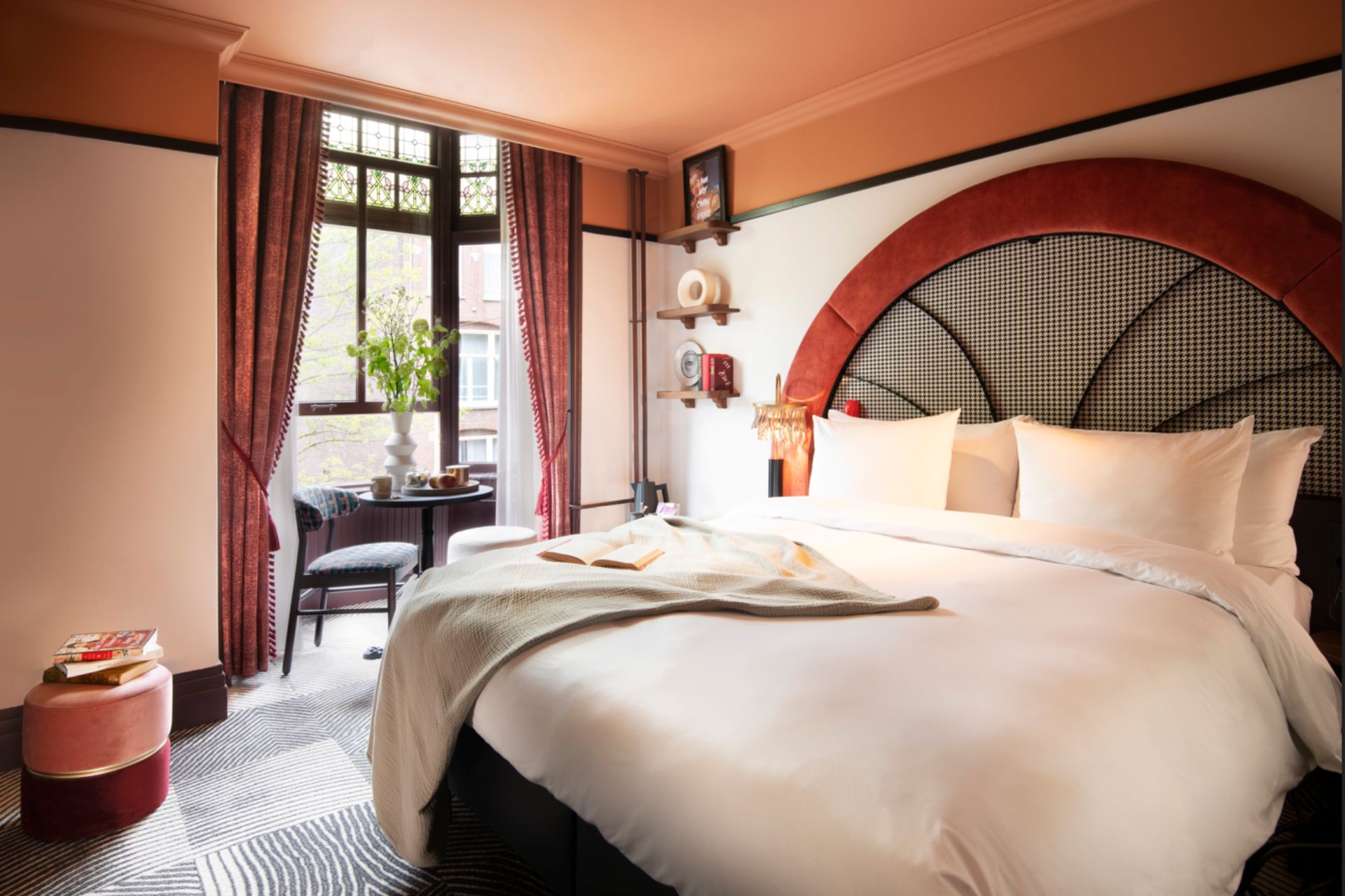 Bedroom with curved red headboard, orange accents, and white bed linens.