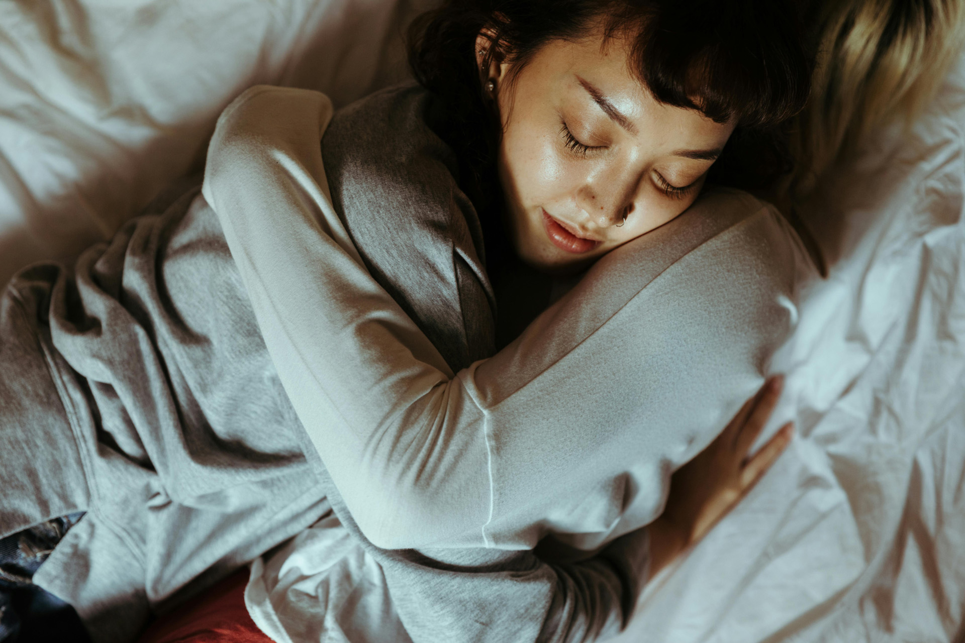 Two women cuddling in bed