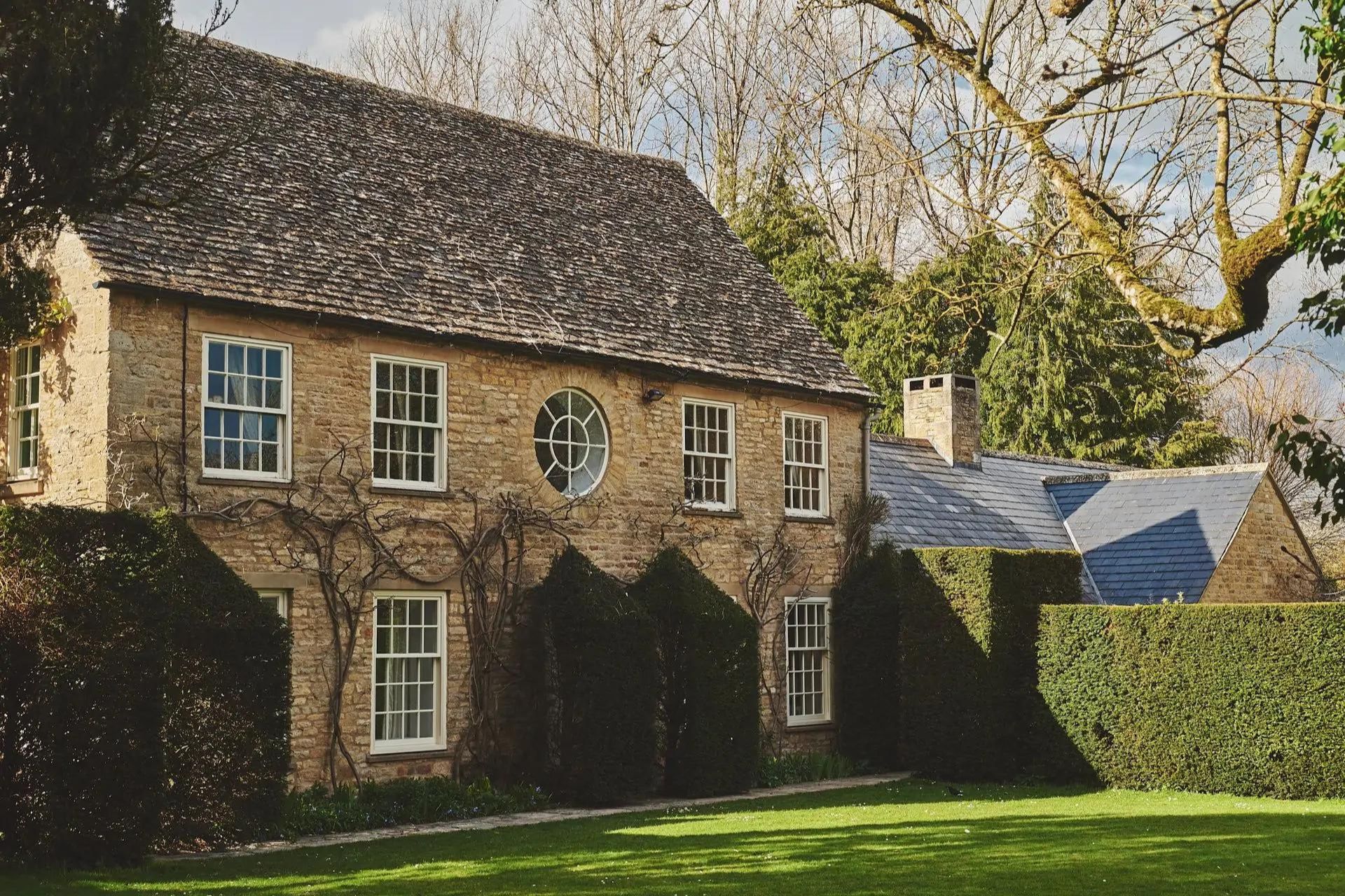 Cotswold stone cottage with lawns and a box hedge