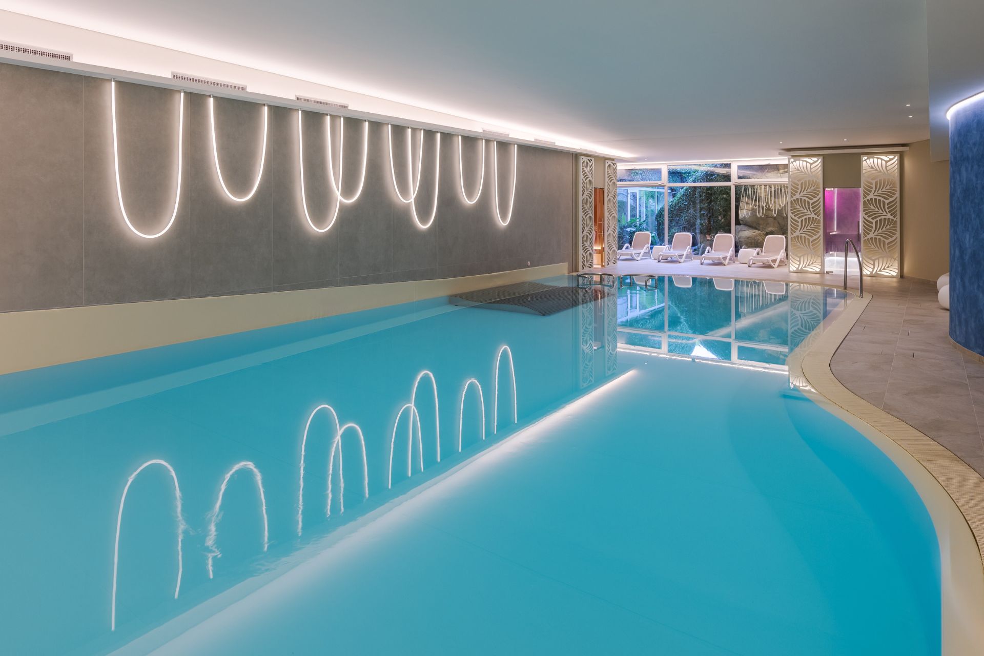 Underground pool with white sun loungers.