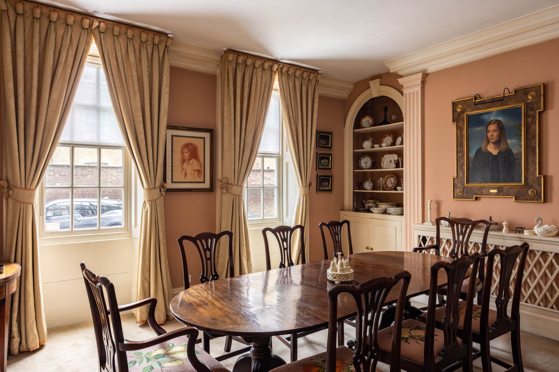 Dining room with terracotta-coloured walls and dark wooden furniture a