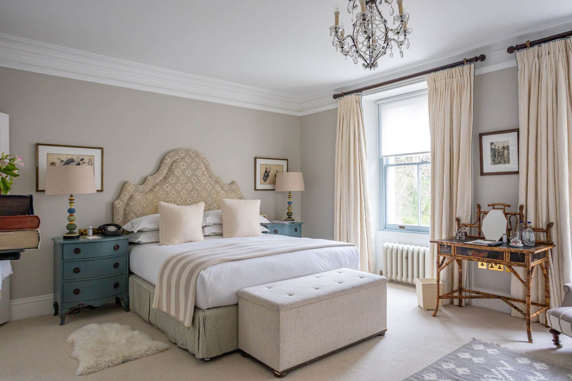 Bedroom with cream headboard and chandelier