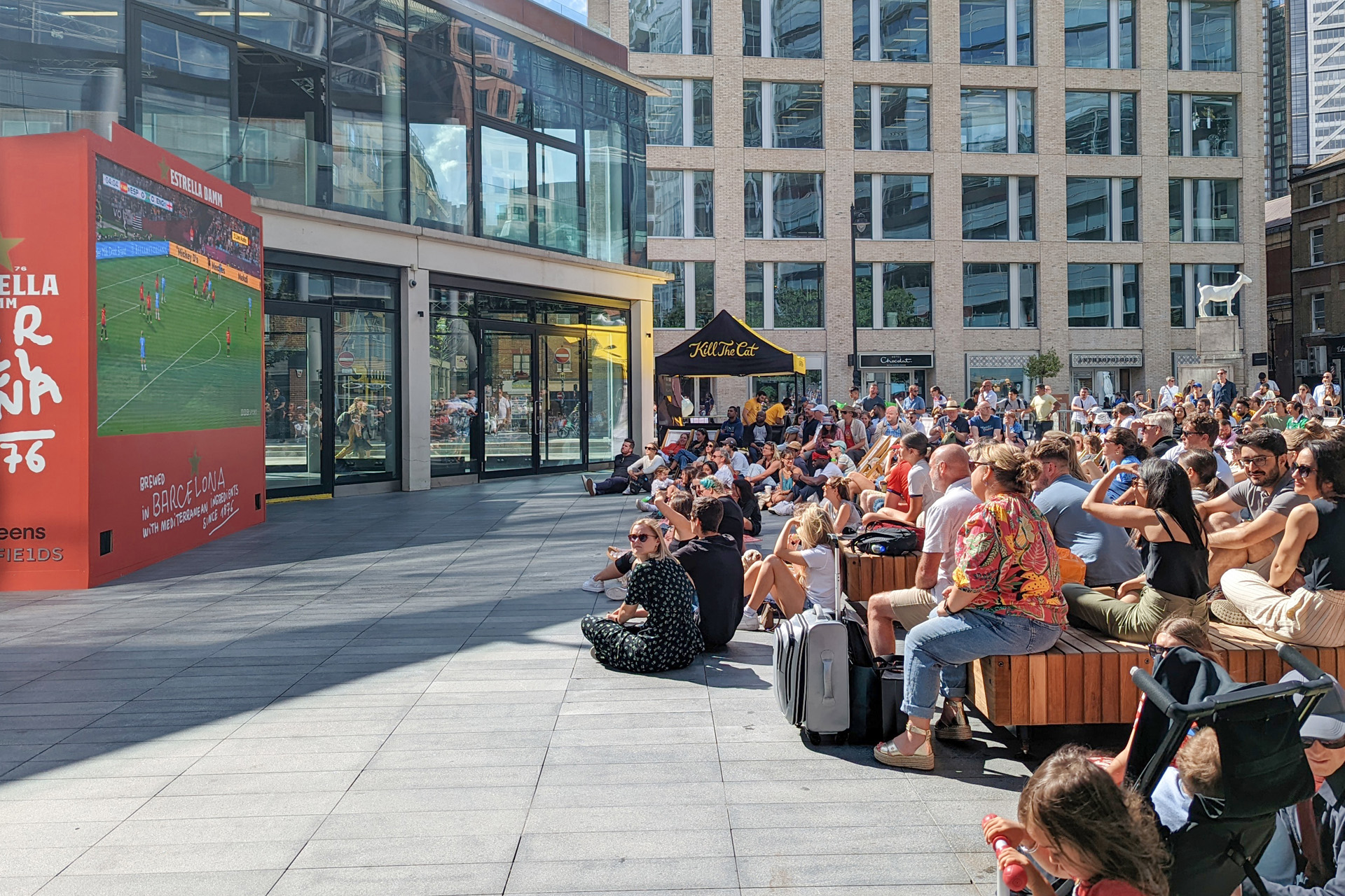 A crowd watching football on a big screen