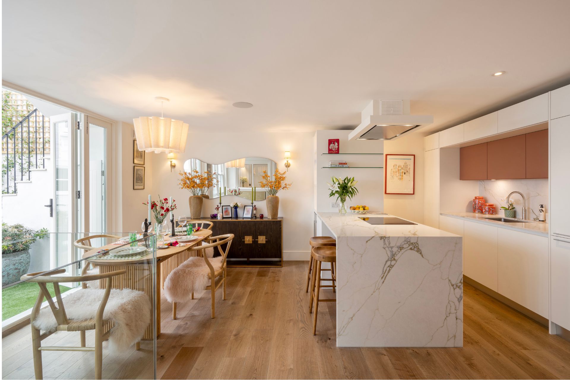 Kitchen with wooden floors, quartz island and dining table.