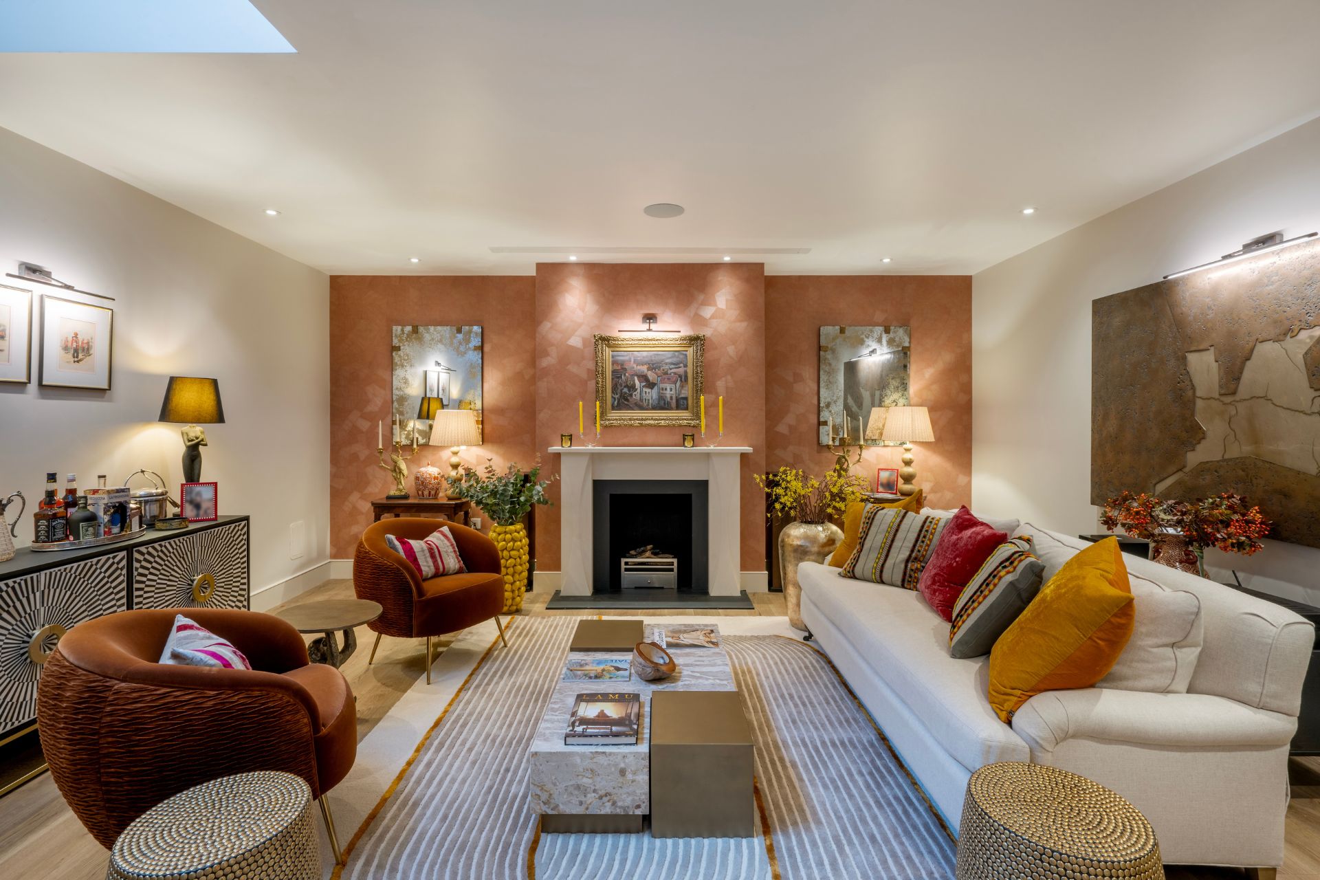 Living room with white sofa, red armchairs, a fireplace and a terracotta feature wall.