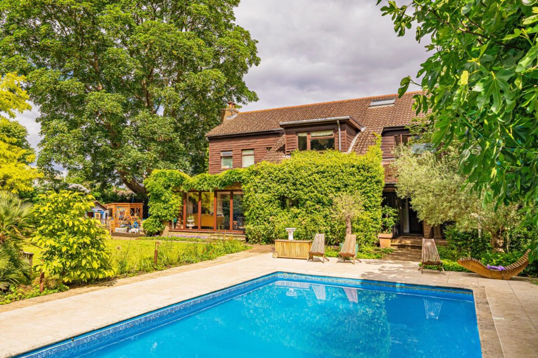Red brick house with trees and outdoor pool
