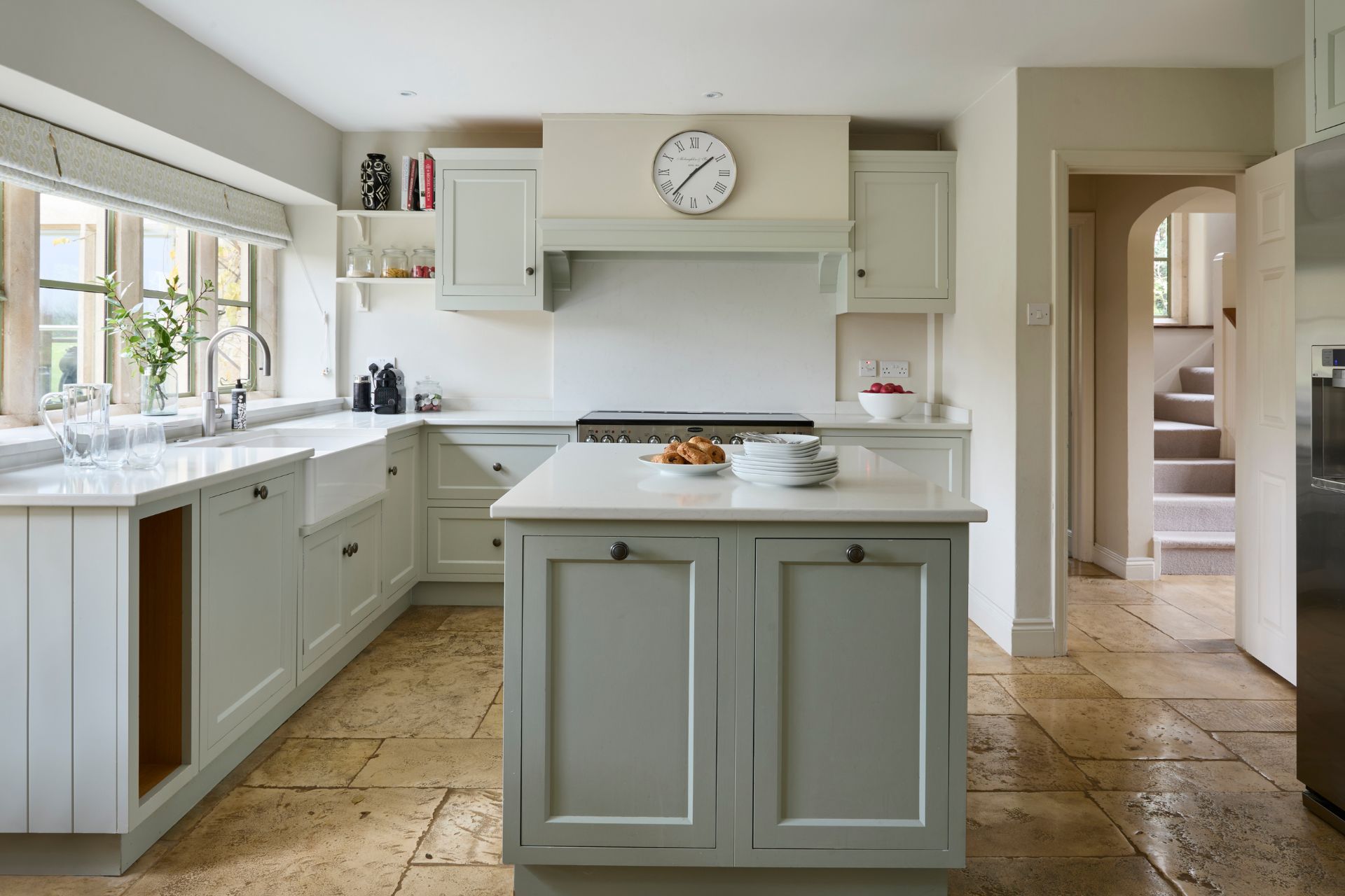 Country kitchen with duck egg blue island and white cabinets.