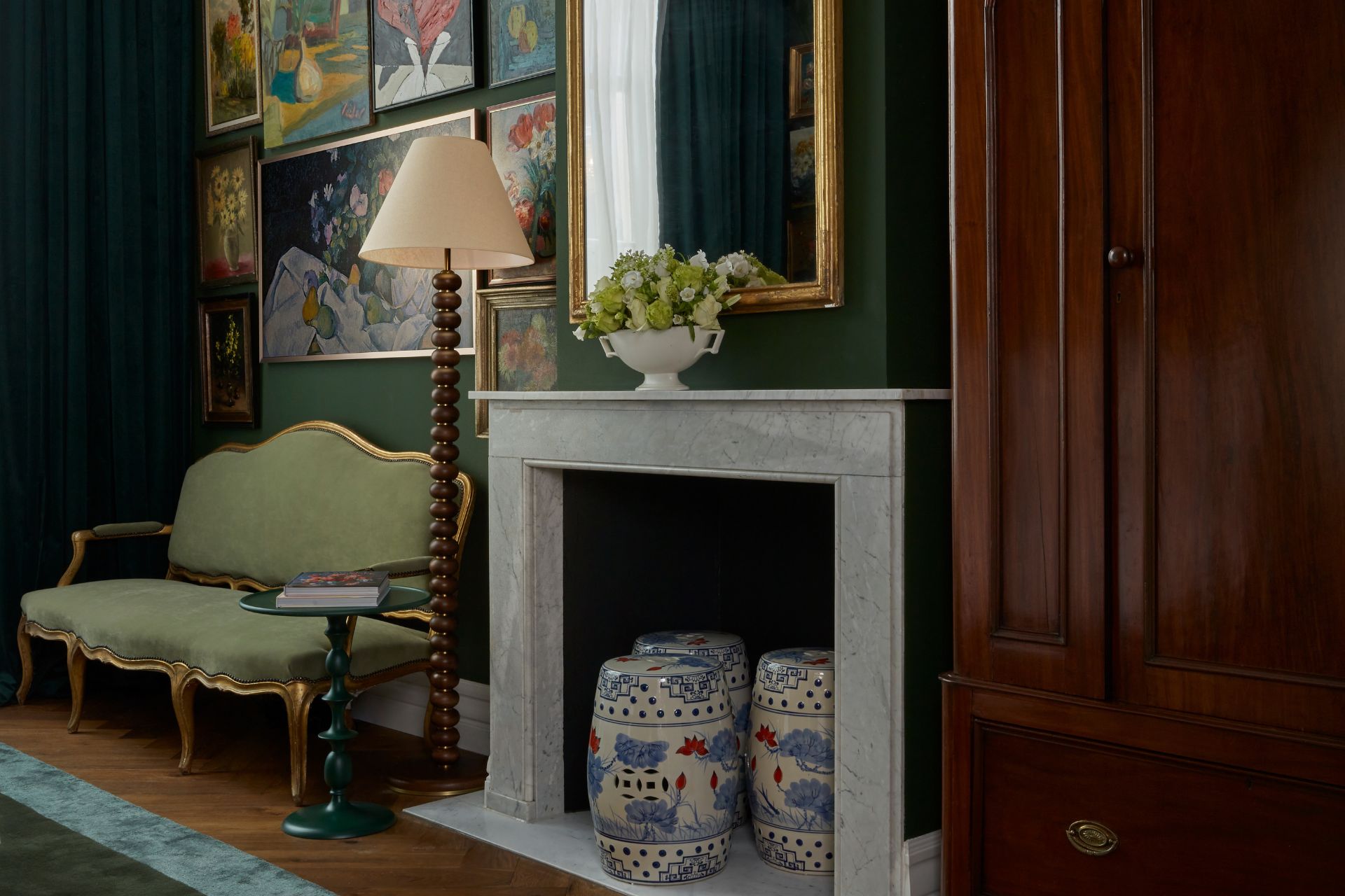 Hotel room with marble fireplace and sage green sofa.