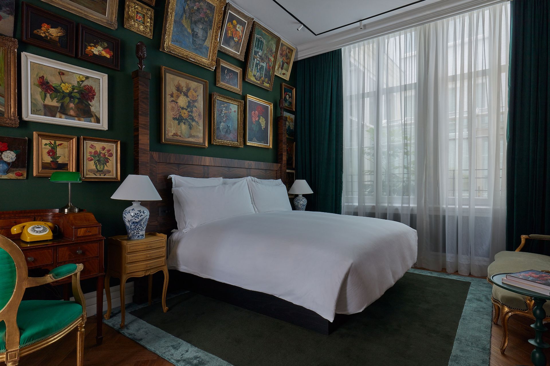 Hotel bedroom with Van Gogh paintings and white bed linen.