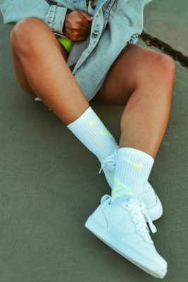 Close up of legs and feet with white trainers