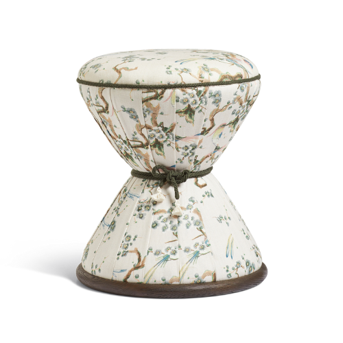 Cream hourglass-shaped footstool with floral detail