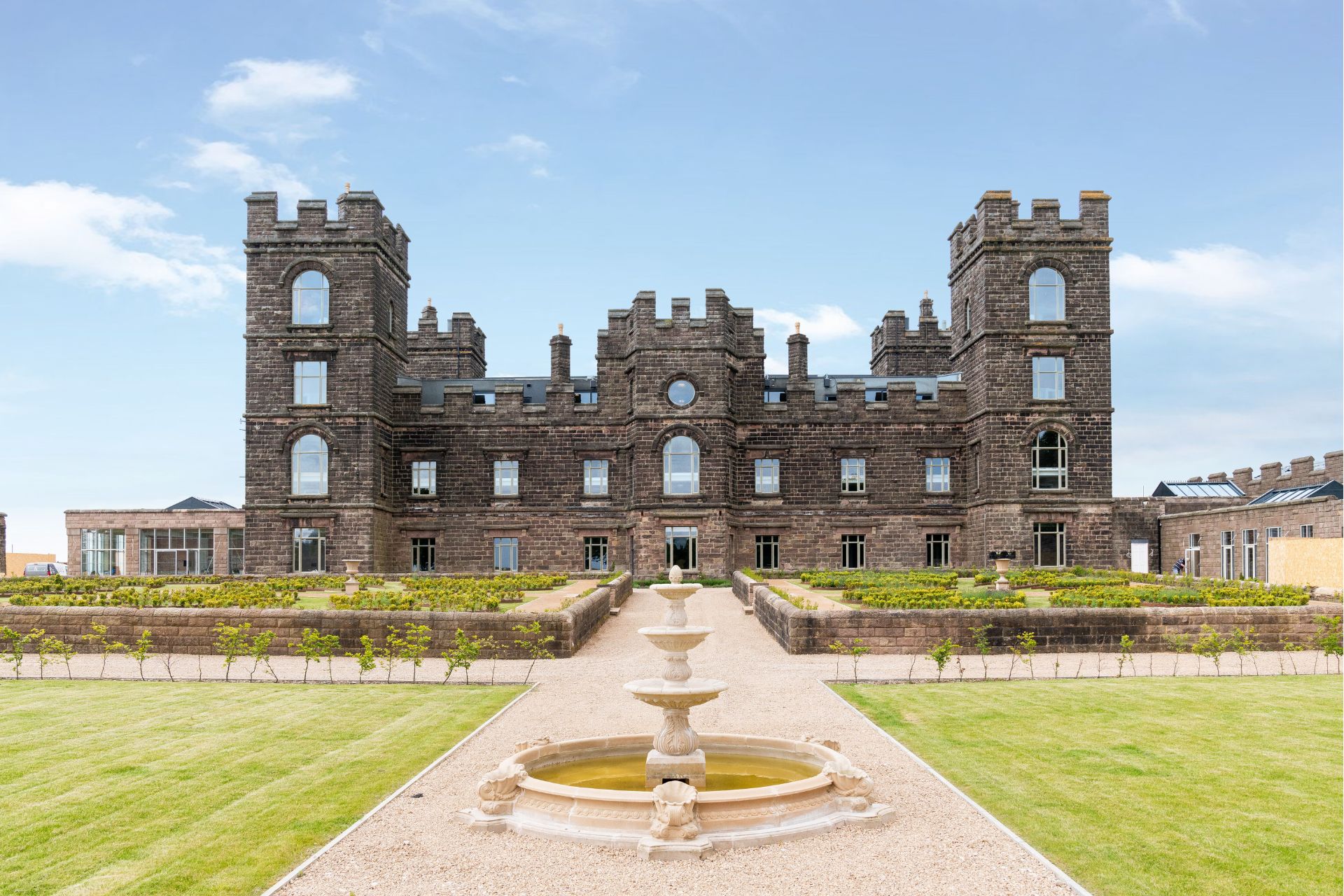 Riber Castle exterior with lawns and fountain