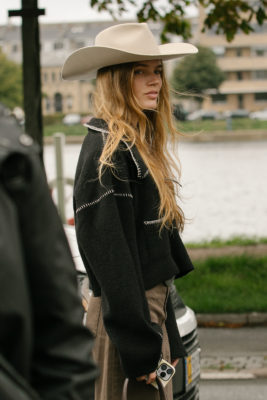 Woman with brookie blonde hair wearing cowboy hat