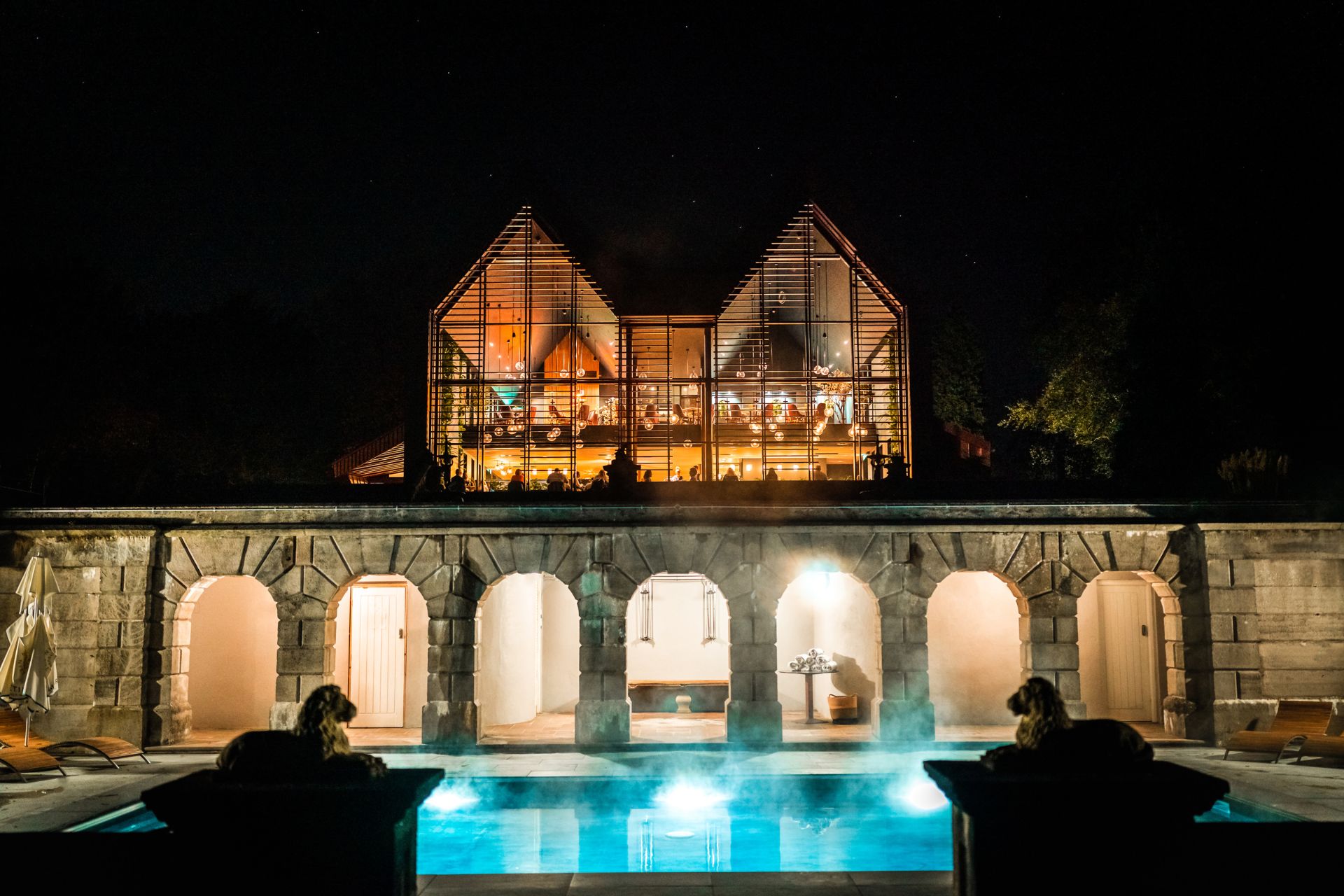 Exterior of The Tawny hotel and outdoor pool at night