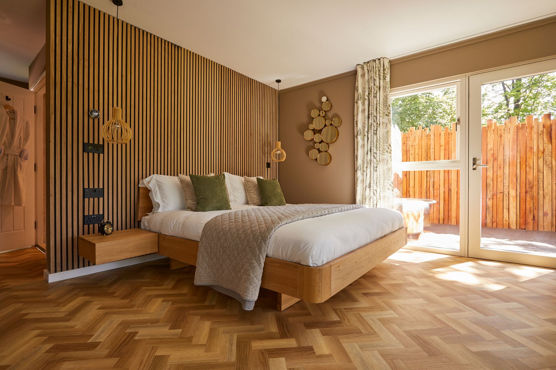 Hotel bedroom with parquet flooring, wood panelling and floor-to-ceiling windows