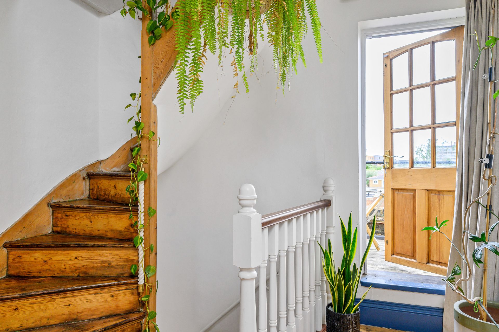 Hallway with wooden staircase and white bannister