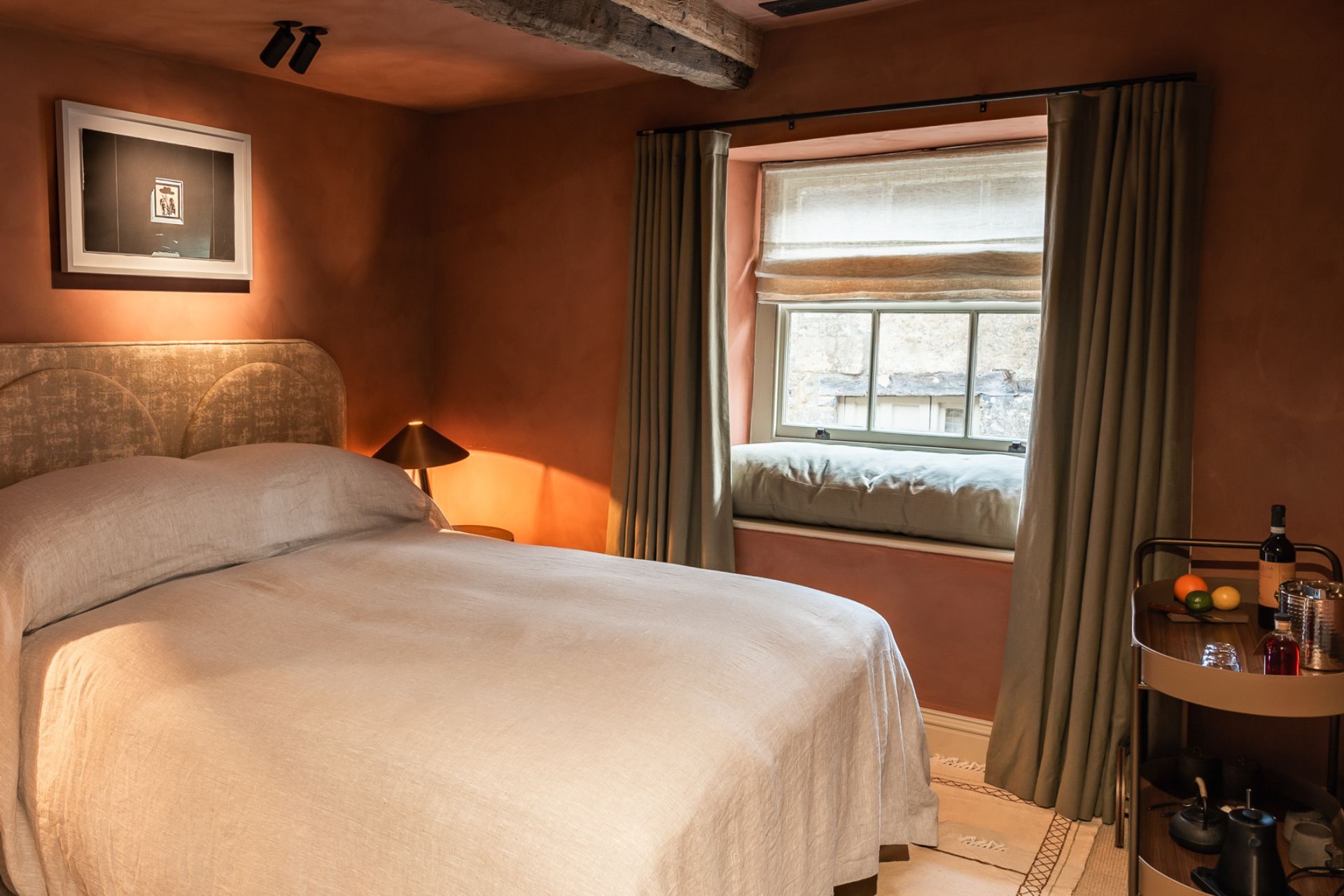 Bedroom with limewash-effect pink walls and white bedding.