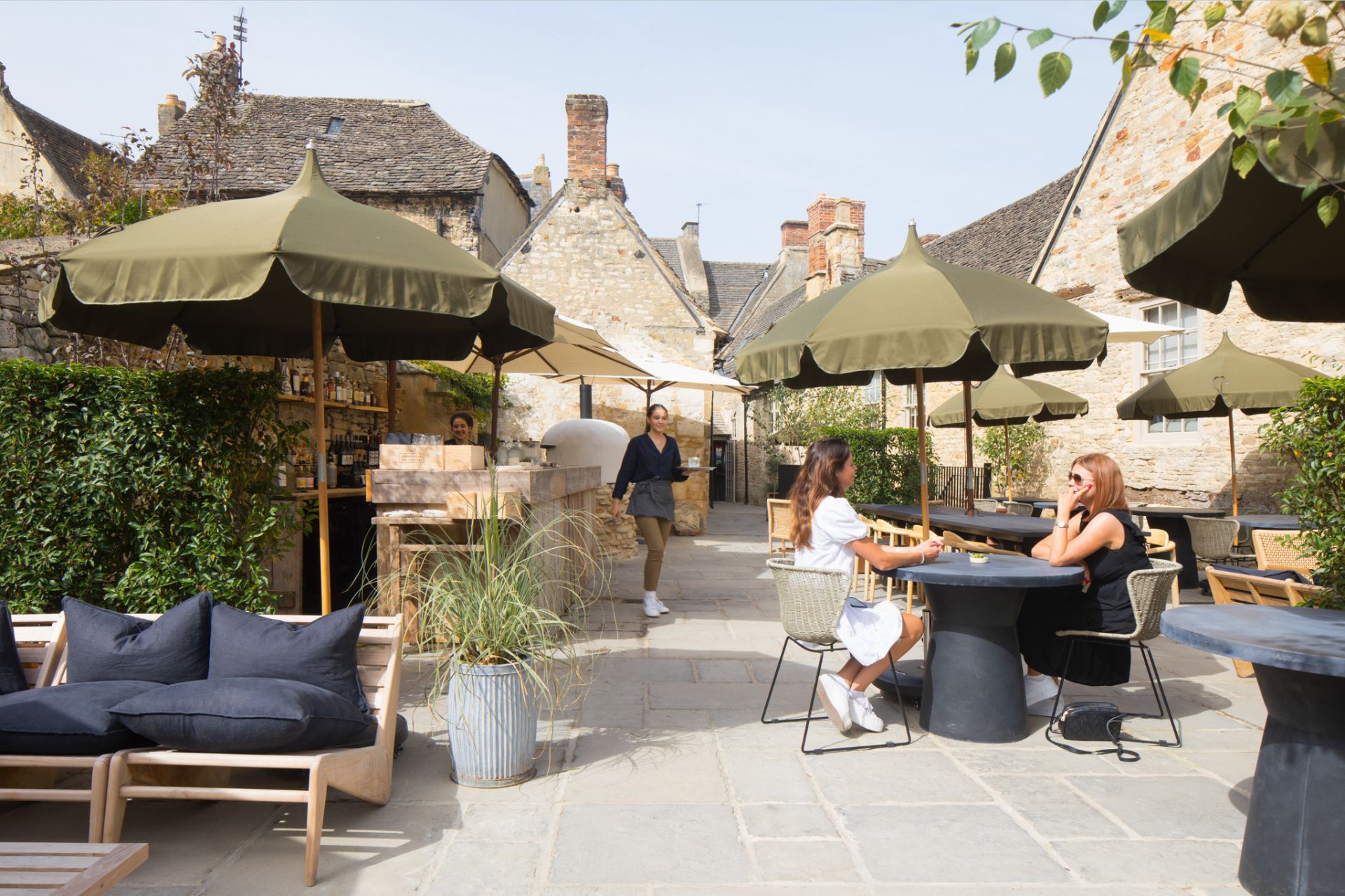 Outdoor dining area with plants and khaki green parasols.