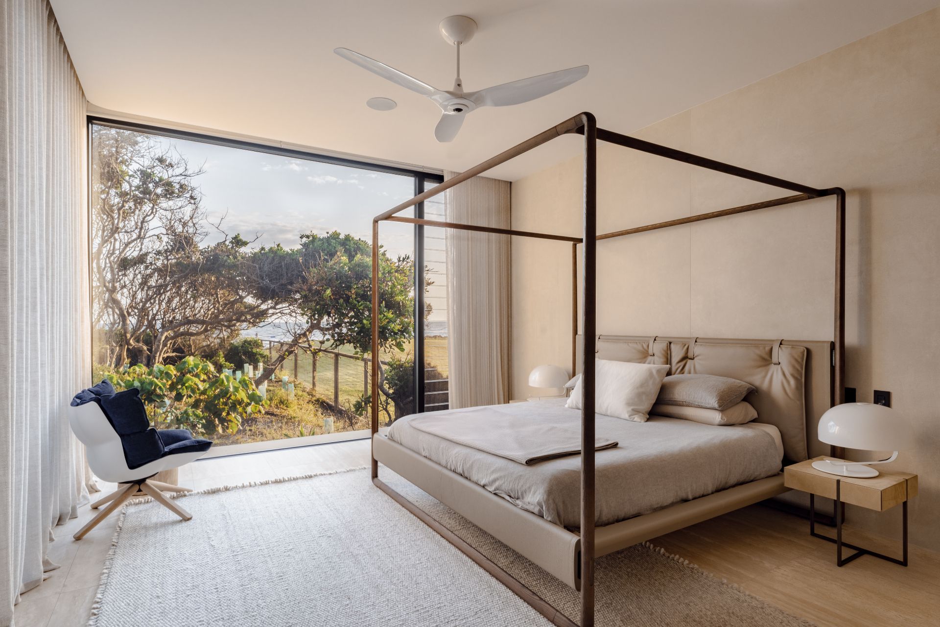 Bedroom with floor-to-ceiling windows and a four-poster bed.