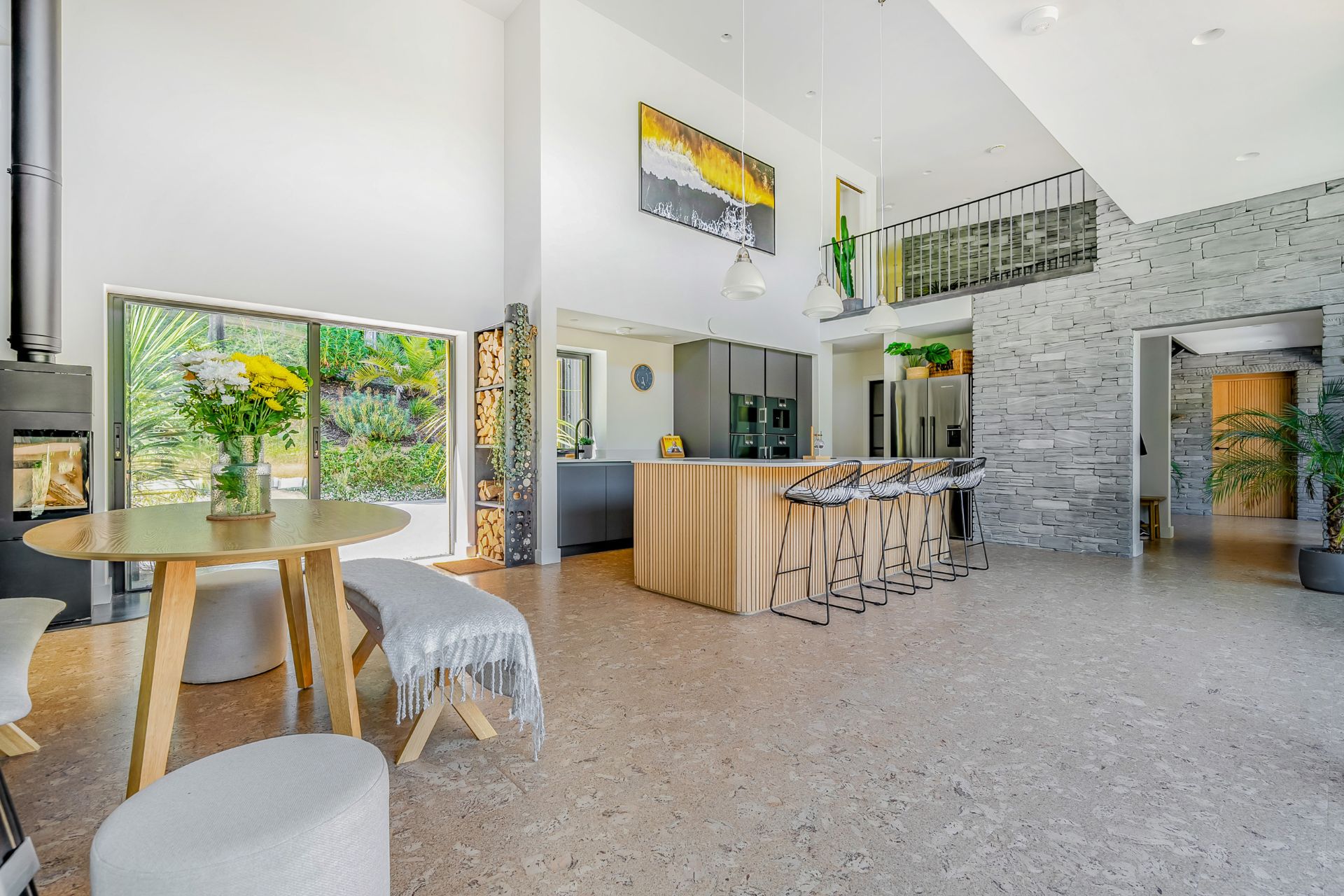 Kitchen with granite floors, wood-panelled island and floor-to-ceiling windows.