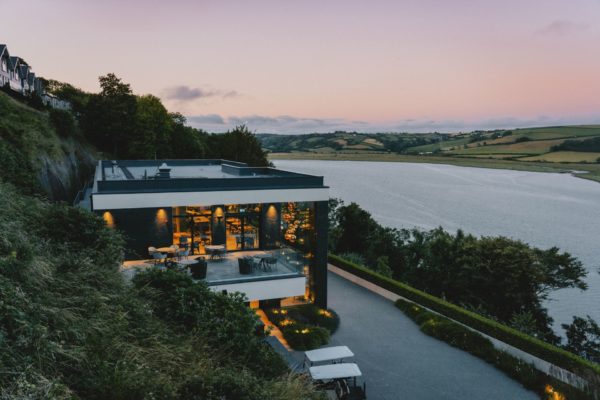 Modern coastal building with a terrace and floor-to-ceiling windows