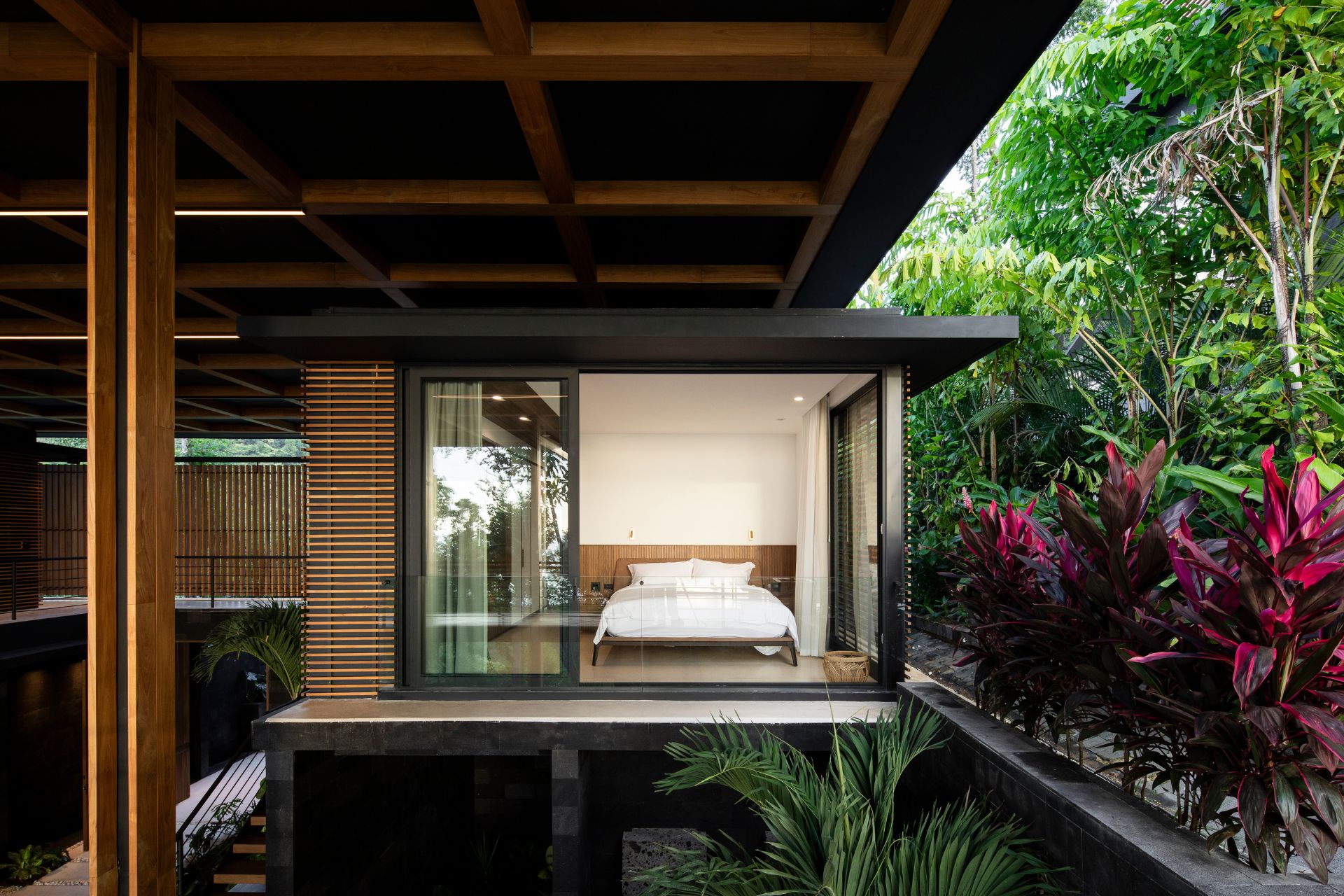 Bedroom suite with floor-to-ceiling windows and jungle views