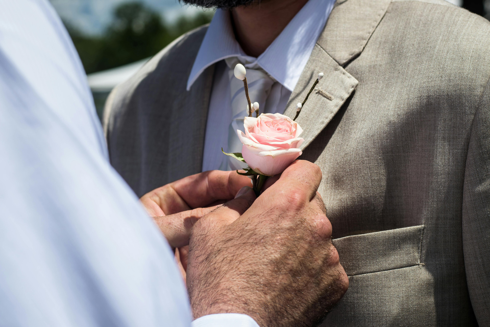 A flower being pinned to a suit