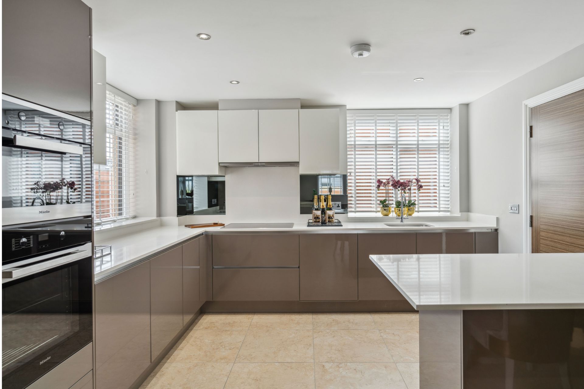 Modern kitchen with taupe cabinets and white countertops
