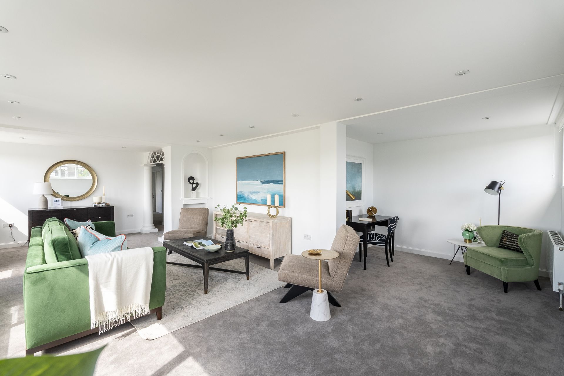 Living room with grey carpet and green velvet sofas