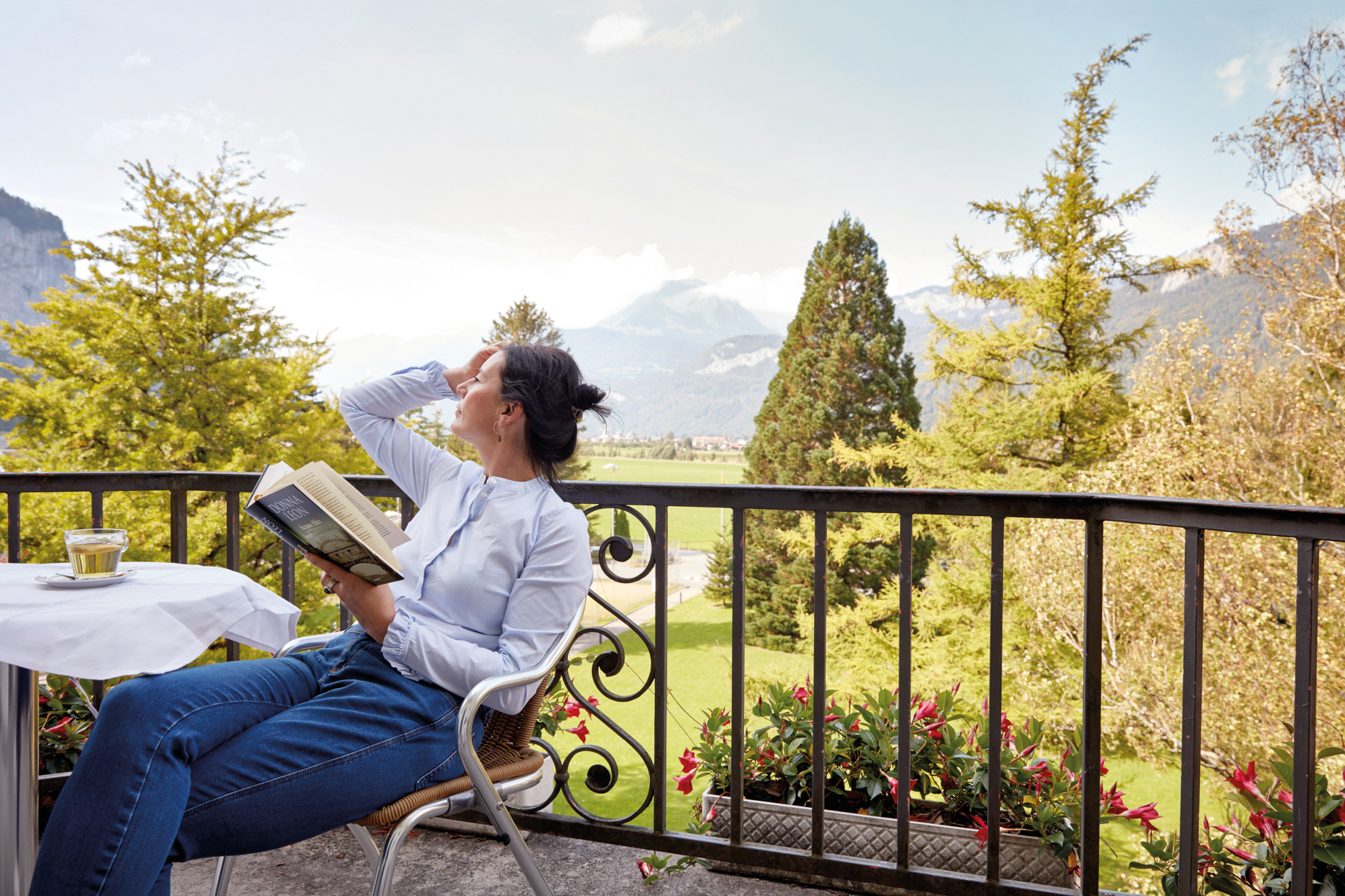 Woman relaxing at table on outdoor balcony