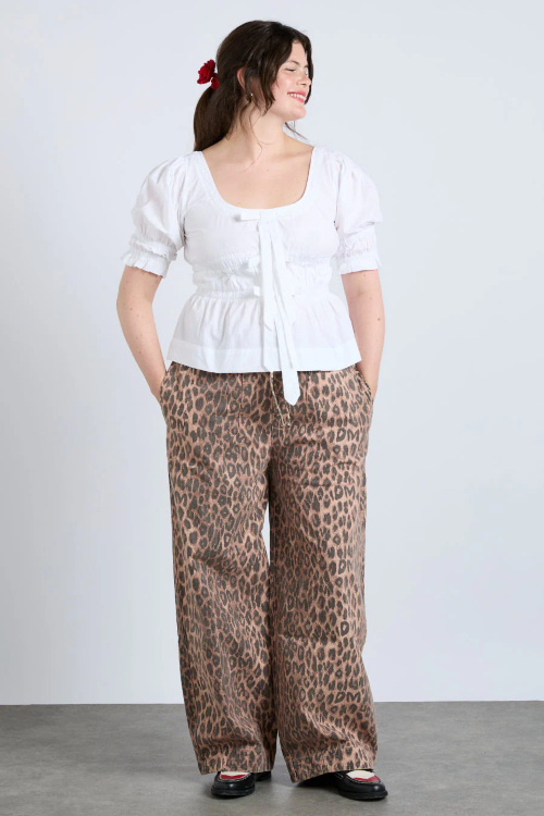 Woman in white top and leopard print jeans