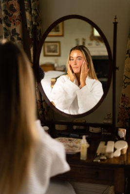 Woman doing skin routine in mirror