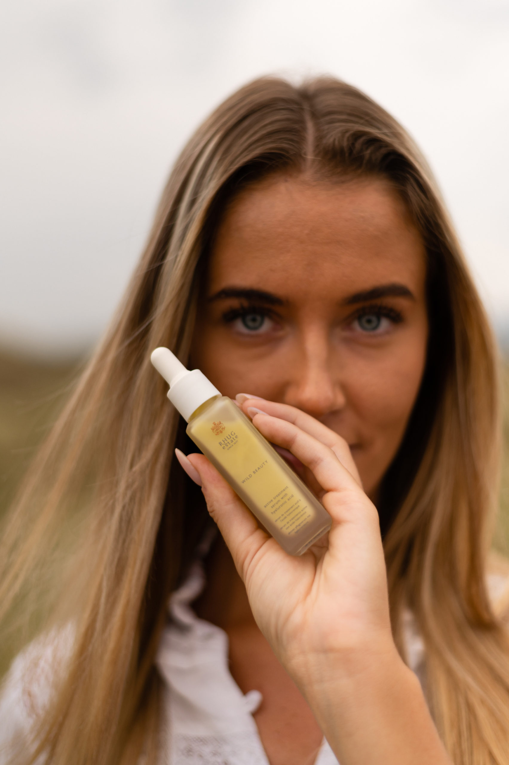 Woman holding organic beauty product in front of face