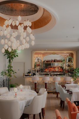 Bar with cream chairs and pink banquettes