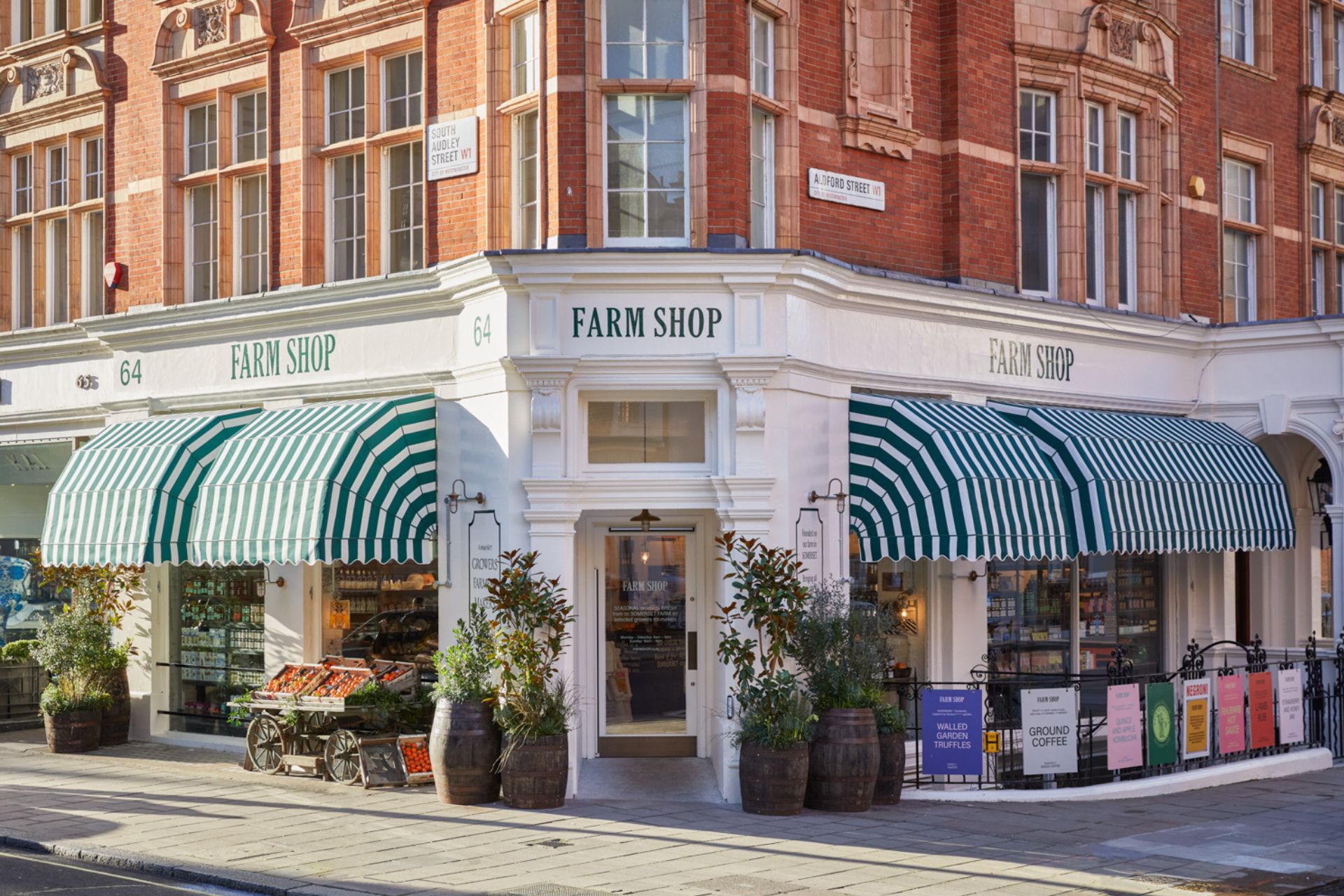 White shop exterior with green and white striped porticos