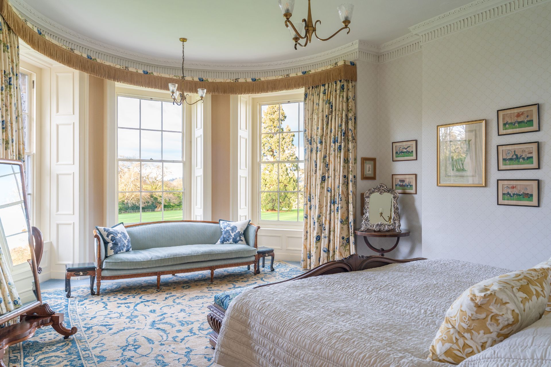 Bedroom with curved bay window, chandelier and double bed