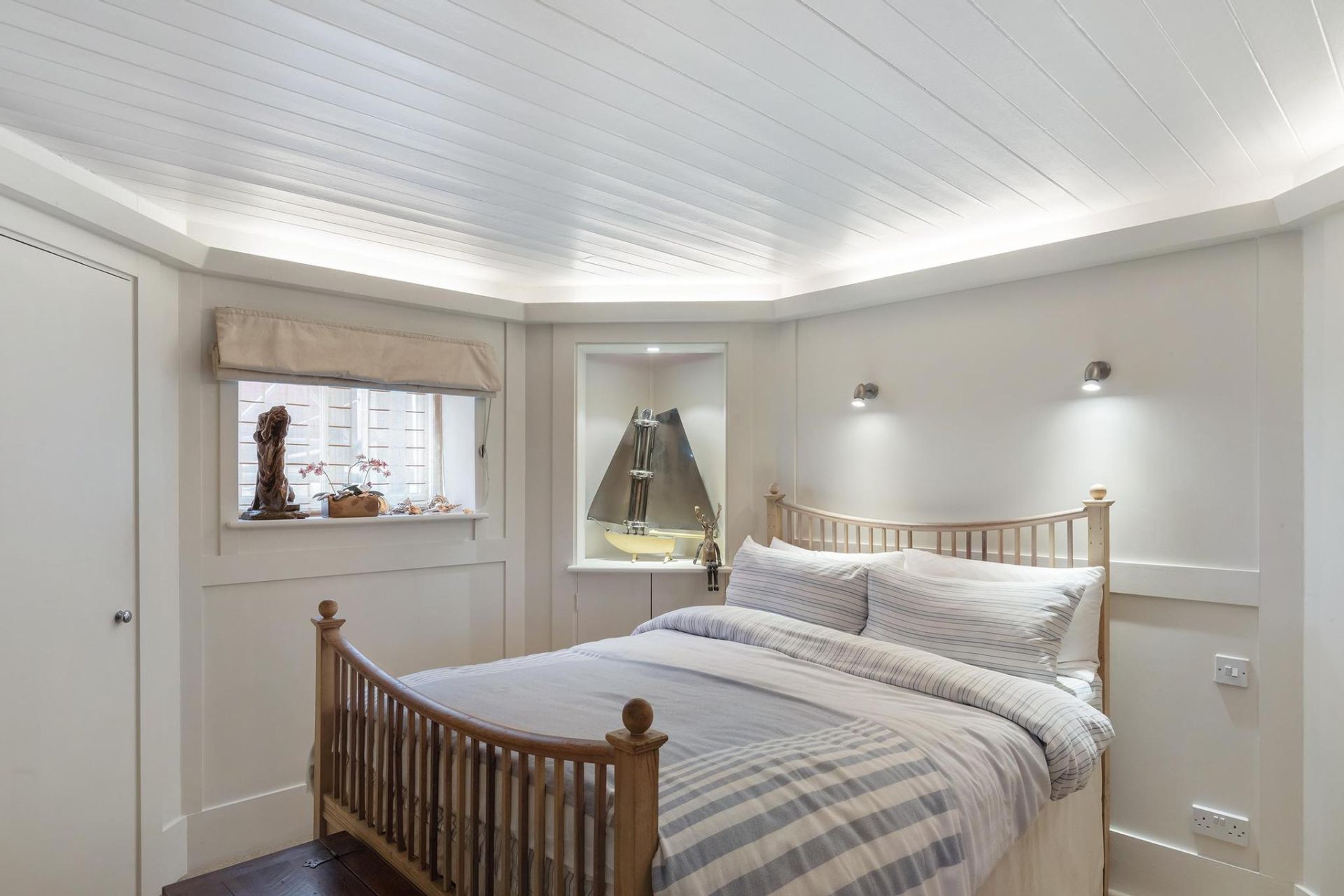 Houseboat bedroom with white wood panelling