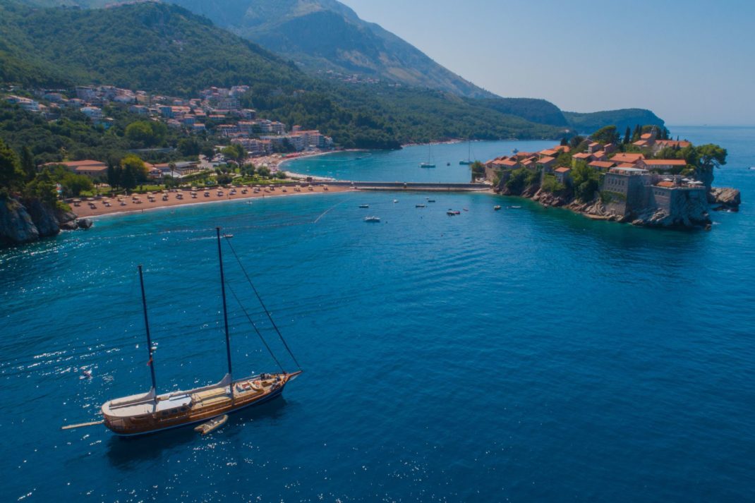 Gulet boat next to Sveti Stefan, a private island in Montenegro
