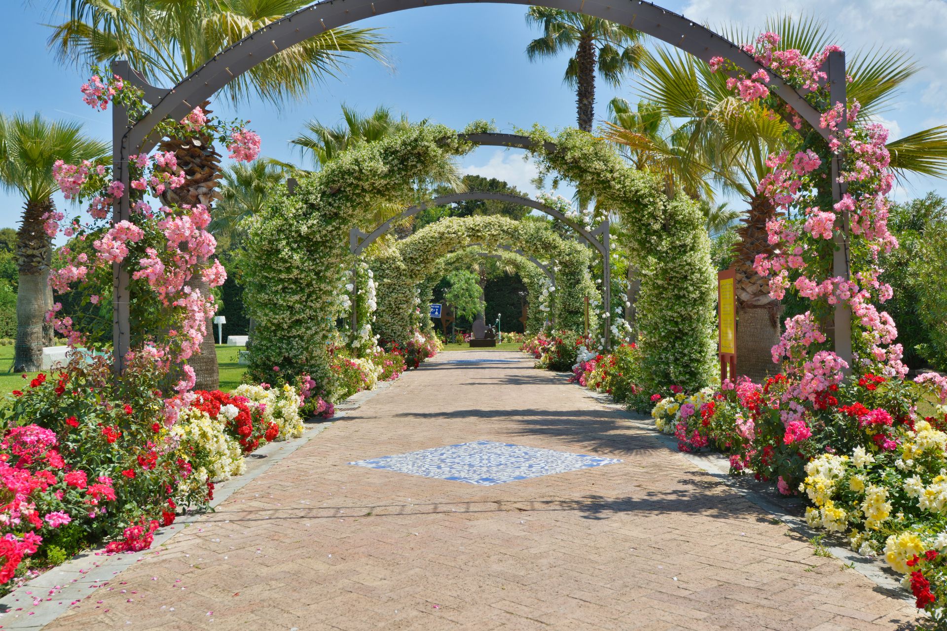 Gravel walkway surrounded by flower arches